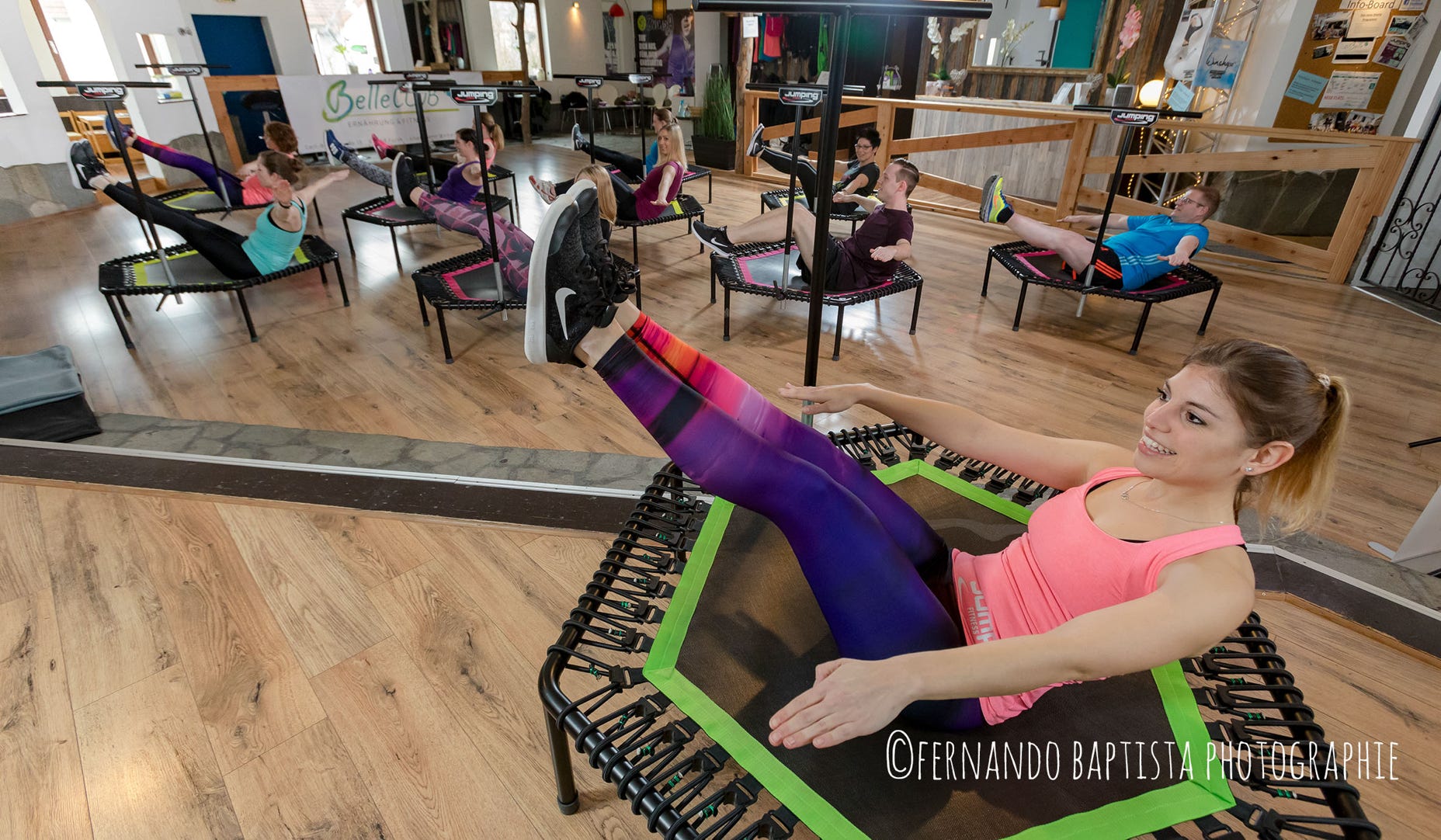 Vorturnerin im Fitness-Studio auf einem Trampolin.